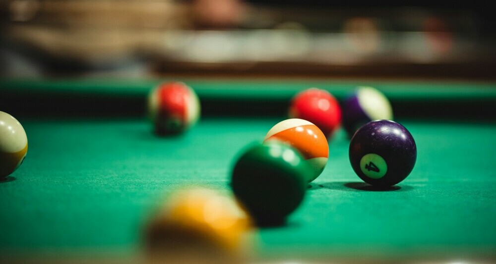 Pool table with spots and stripes on green baize Pool table with spots and stripes on green baize