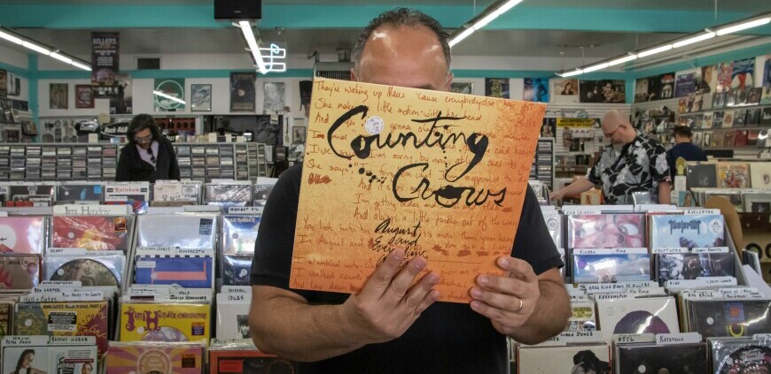 A record shop interior. Man holding a Counting Crows record. Please note there are no Counting Crows records in my collection